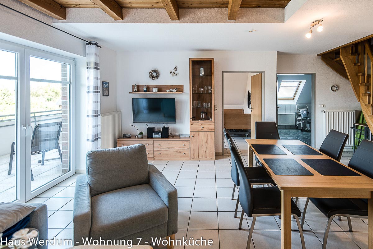 Offener Wohn- und Essbereich der Wohnung 7 mit Esstisch, Balkonzugang und Verbindungen zu angrenzenden Räumen. Geprüft sind 160 cm schmalster Durchgang im Wohnraum und ein unterfahrbarer Esstisch.