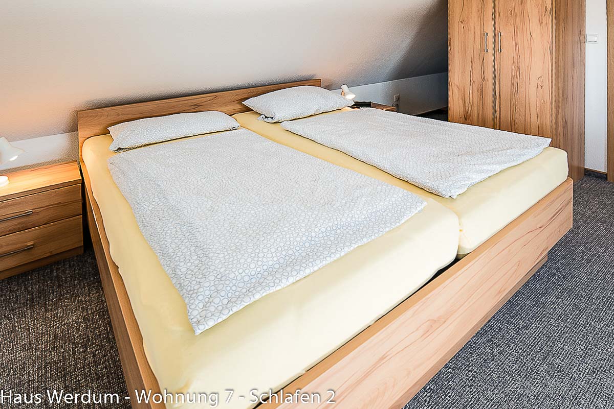 Detailansicht der zwei nebeneinanderstehenden Betten im Schlafzimmer 2 der Wohnung 7. Der Schlafraum liegt im Obergeschoss und ist wegen des ausschließlichen Zugangs über die Holztreppe nicht stufenlos und nicht barrierefrei erreichbar.