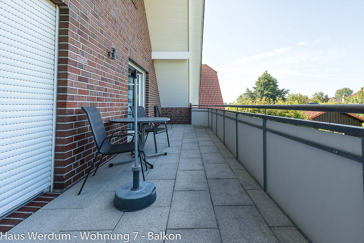 Balkon der Wohnung 7 mit großer freier Bewegungsfläche, Sitzmöbeln, Tisch und Sonnenschirm. Der geprüfte Bewegungsraum beträgt 242 × 850 cm; am Zugang vom Wohnbereich besteht eine dokumentierte Türschwelle von 2 cm. Die freie Fläche zwischen Sitzmöbeln und Geländer macht die großzügigen Bewegungsmöglichkeiten auf dem Balkon anschaulich.