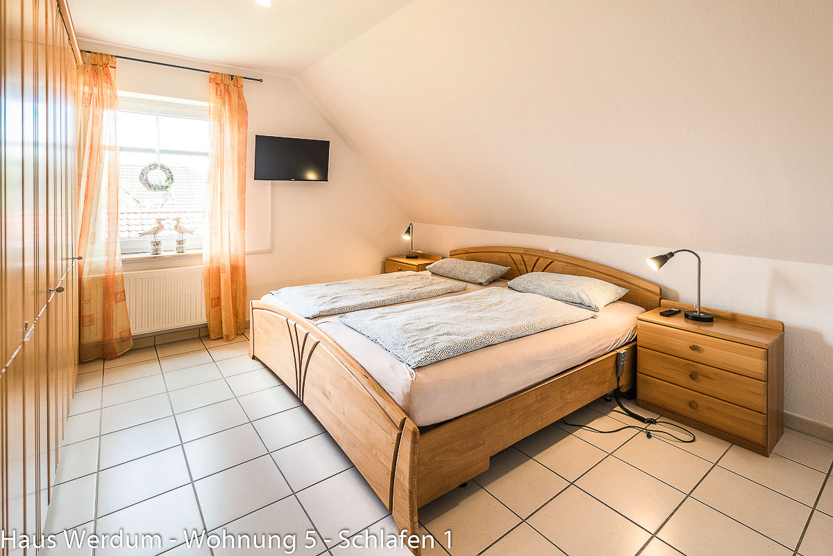 Barrierefreies Schlafzimmer mit Doppelbett, Fliesenboden und Freiraum für Rollstuhlfahrer in Wohnung 5 Haus Werdum.