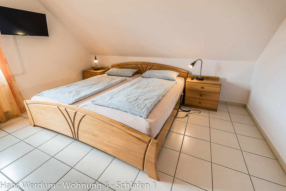 Barrierefreies Doppelbett aus Holz mit schwellenlosem Fliesenboden und Freiflächen in Wohnung 5 im Haus Werdum