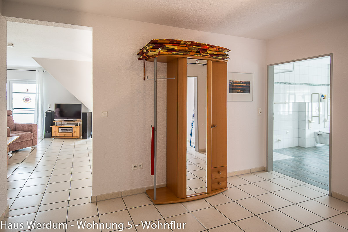Schwellenloser Wohnflur in Wohnung 5 im Haus Werdum mit hellem Fliesenboden, breiten Durchgängen zum Wohnzimmer und freiem Zugang zum rollstuhlgerechten Badezimmer mit Haltegriffen